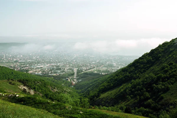 Malerischer Blick auf Gelendschik: die bewaldeten Berge umgeben eine kleine Stadt mit Ziegelhäusern an der Schwarzmeerküste — Stockfoto