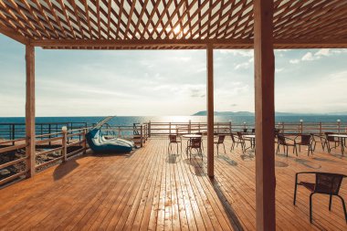 Ahşap Teras manzaralı deniz ve gün batımı resort seyahat kavramı