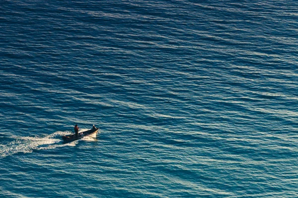 Solitario barco navega a lo largo de la hermosa superficie azul del mar, concepto de avanzar y superar las dificultades —  Fotos de Stock