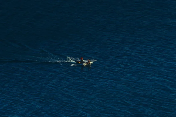 Żagle samotny łodzią wzdłuż piękny niebieski powierzchnia morza, pojęcie ruchu do przodu i przezwyciężanie trudności — Zdjęcie stockowe