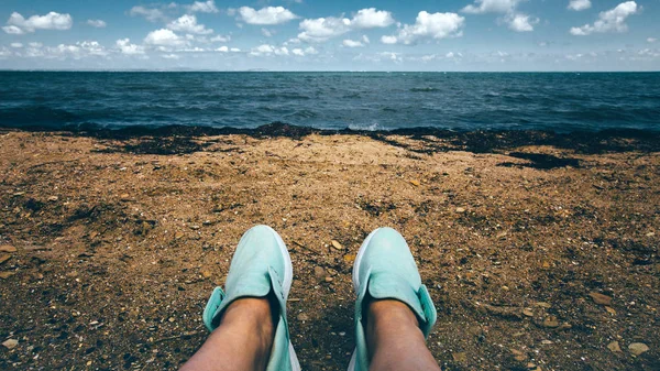 Piernas femeninas en zapatillas Descanso en la playa a lo largo del mar Concepto — Foto de Stock