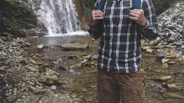 Hands Unrecognizable Man Holds Backpack Strap On Waterfall Background Hiking Journey Travel Trek Concept — Stock Photo, Image