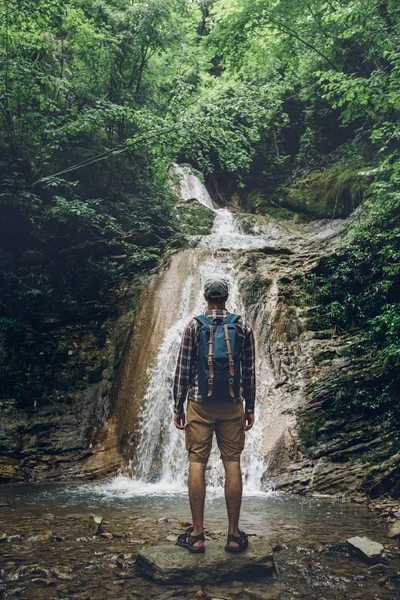 Traveler Explorer fica na rocha e goza de vista da natureza selvagem, vista traseira. Caminhadas conceito de aventura — Fotografia de Stock