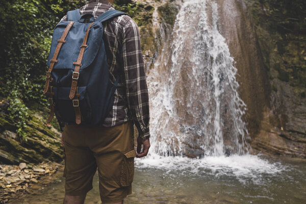 Unrecognizable Young Man Has Reached Destination And Enjoying View Of Waterfall. Journey Hiking Adventure Concept