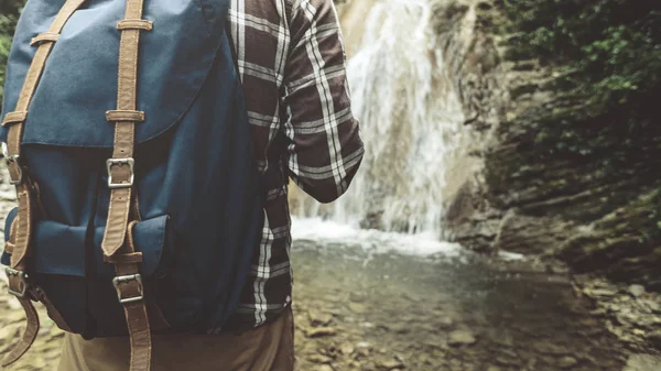 Viajante irreconhecível com mochila atingiu seu e fica em cachoeira fundo close-up caminhadas viagem viagem trek conceito — Fotografia de Stock