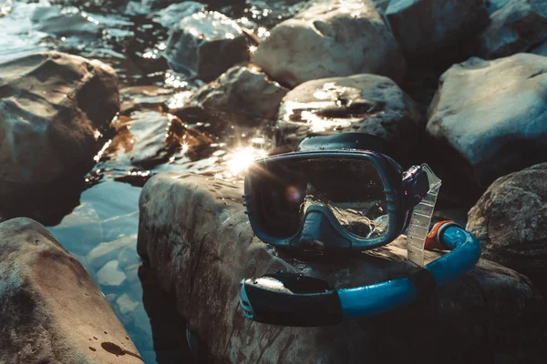 Mask för dykning och snorkla ligga på stranden, på klipporna. Turism och resor-konceptet — Stockfoto