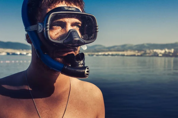 Buceador masculino con máscara y tubo de pie en la playa en el fondo de la orilla del mar —  Fotos de Stock