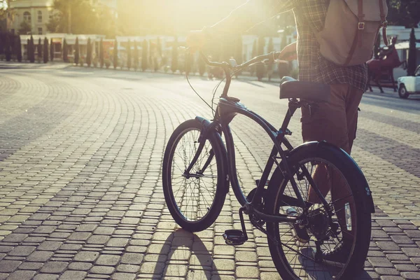 Hombre irreconocible camina con una bicicleta en la plaza de verano en el estilo de vida de rutina diaria de la mañana — Foto de Stock