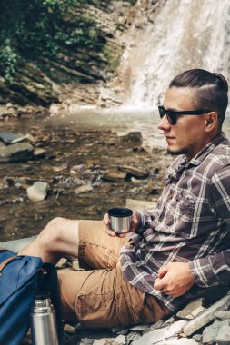 Erkek uzun yürüyüşe çıkan kimse dinlenme ve çay içmek ya da boş zaman tatil seyahat kavramı Hiking termos kahve