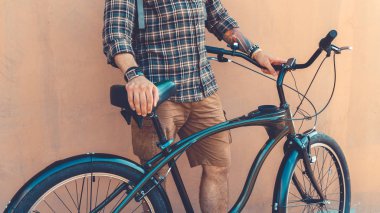 Tanınmayan genç Hipster adam Onun Bisiklet duvar tatil etkinlik kavramı yakın dururken elele