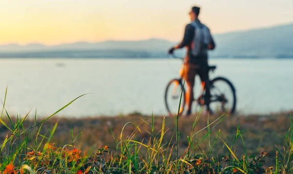 Hombre ciclista irrecobnizable de pie con bicicleta en la costa y disfrutando de la vista de la naturaleza Vacaciones al atardecer Destino viajero Concepto de descanso, enfoque selectivo — Foto de Stock