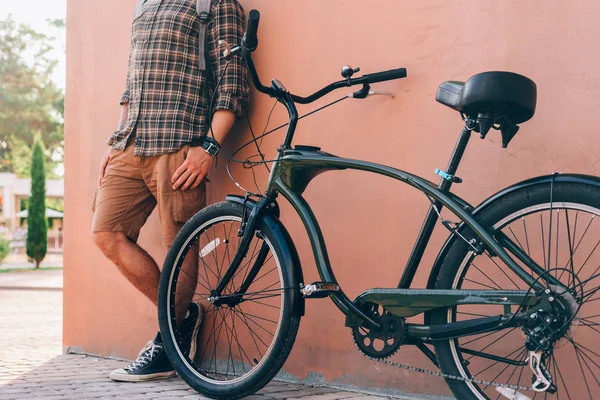 Hombre adulto irreconocible de pie con bicicleta cerca de la pared Rutina diaria Estilo de vida Concepto de descanso — Foto de Stock