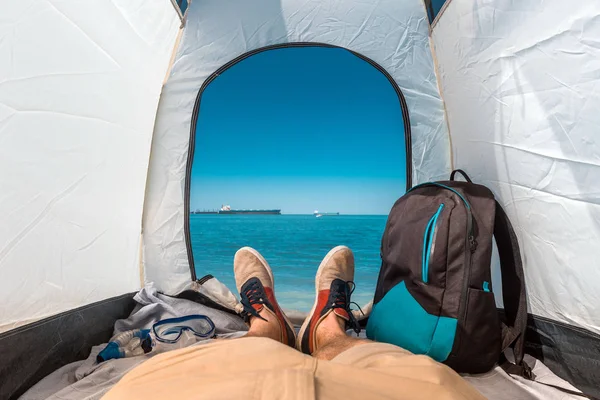 Traveler Man Sentado em uma tenda turística por The Sea Summer Beach Holiday Vacation Concept. Vista das Pernas. Ponto de vista tiro — Fotografia de Stock