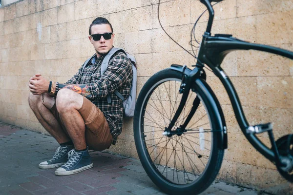 Guapo joven turista sentado con bicicleta de engranaje fijo en la calle estilo de vida de rutina diaria — Foto de Stock