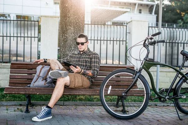 Joven ciclista descansando en el banco y utilizando la tableta Conexión de comunicación Dispositivos digitales Concepto de tecnología — Foto de Stock