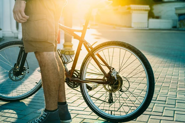 Oigenkännlig ung Man med cykel stående på gatan vid soluppgången dagliga rutin livsstil — Stockfoto