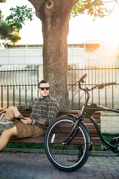 Joven ciclista descansando en el banco y utilizando la tableta Comunicación Conexión Dispositivos digitales Tecnología Concepto — Foto de Stock