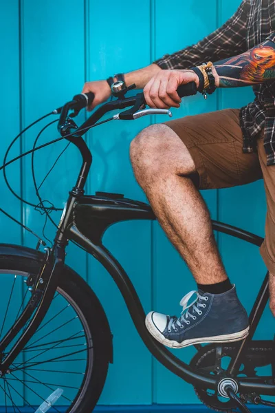 Hombre adulto irreconocible sentado en una bicicleta a lo largo de una pared azul Antecedentes Estilo de vida diario Urban Resting Concept — Foto de Stock