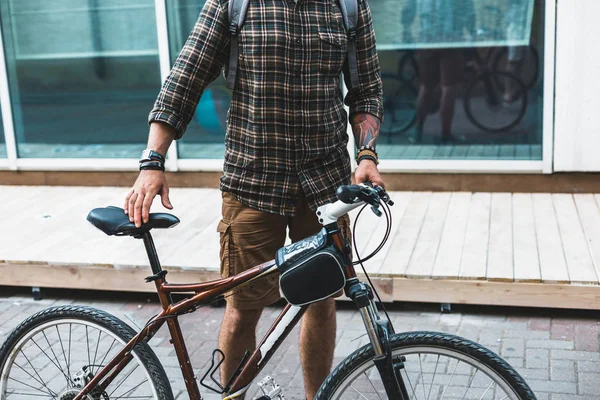 Hombre ciclista irreconocible con bicicleta caminando por la calle — Foto de Stock