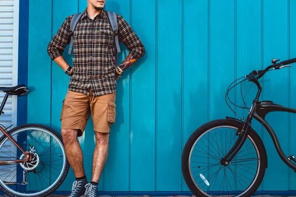 Hombre viajero adulto se para con una bicicleta cerca de la pared azul Estilo de vida diario Urban Resting Concept — Foto de Stock
