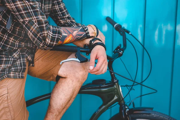 Hombre irreconocible sentado en una bicicleta cerca de la pared azul Antecedentes Estilo de vida diario Urban Resting Concept — Foto de Stock