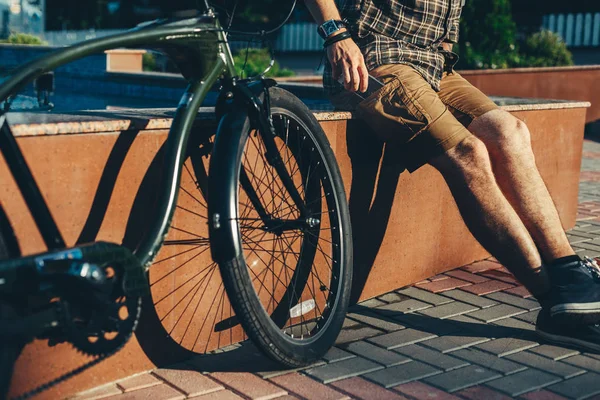 Man cyklist tar ut (sätta) mobiltelefon från (i) fickan, närbild — Stockfoto