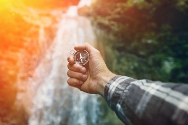 Adam Explorer şelale arka planda, bakış açısı yolculuk seyahat Trek kavramı Hiking pusula ile yön arama