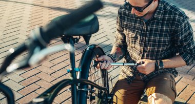 Bisikletçi Preparing için çelme takmak, bakım taşıma kavramı tekerlekli motor, pompa genç adam