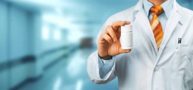 Bir şişe hap Hetween parmaklarını tutan omuz üzerinde Beyaz önlük doktor. Sağlık Tıp hastane kavramı