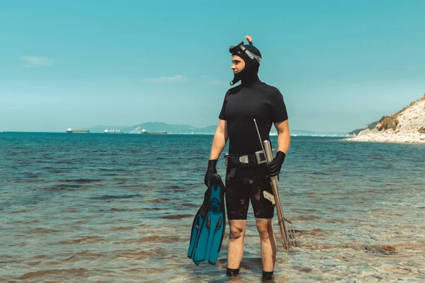 Chasseur sous-marin homme en combinaison de plongée avec équipement va à la mer en été à l'extérieur — Photo