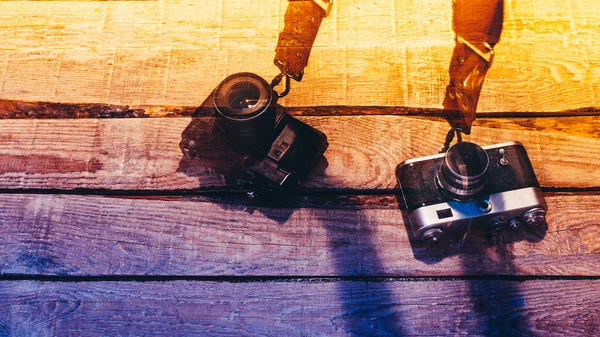 Две винтажные камеры на красочной деревянной поверхности — стоковое фото