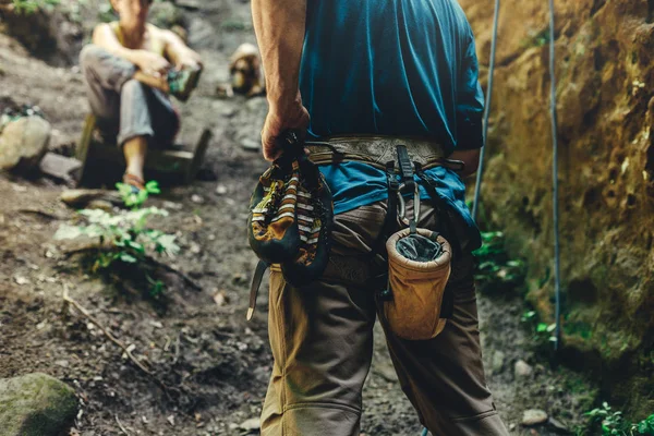 Primer plano de un escalador de muslos con equipo en un cinturón, se para en una roca. Concepto de hobby extremo — Foto de Stock