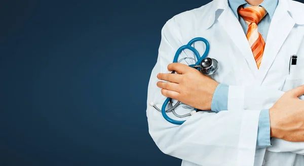 Doctor en capa blanca con un estetoscopio cruza sus brazos sobre su pecho Copia-espacio sobre fondo azul. Concepto de Medicina Sanitaria —  Fotos de Stock