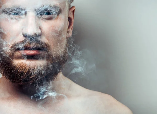 Retrato de un hombre adulto tenso y enfocado con una cicatriz en su cara con humo de cigarrillo. Concepto de mal hábito — Foto de Stock