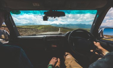Araba sürüş ve elele, mutlu çift arka görünümü. Yol yolculuk macera konsepti