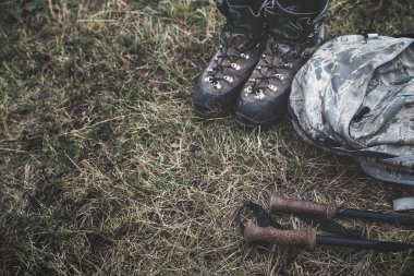 Trekking botları, sopa ve yerde yatan sırt çantası. Seyahat yolculuk yaşam tarzı kavramı