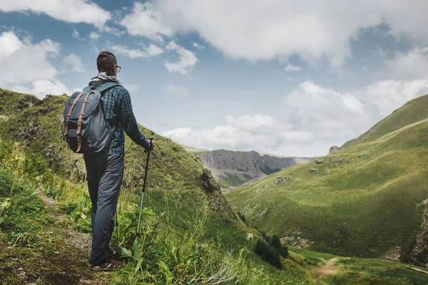 Tramp muž s batohem a trekingových holí položenou a při pohledu na hory v létě venku, zadní pohled — Stock fotografie