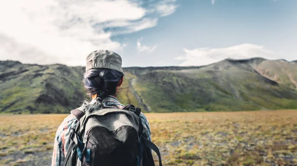 Menina viajante jovem com mochila está envolvida em caminhadas em montanhas, vista traseira. Turismo Aventura Estilo de Vida Conceito — Fotografia de Stock