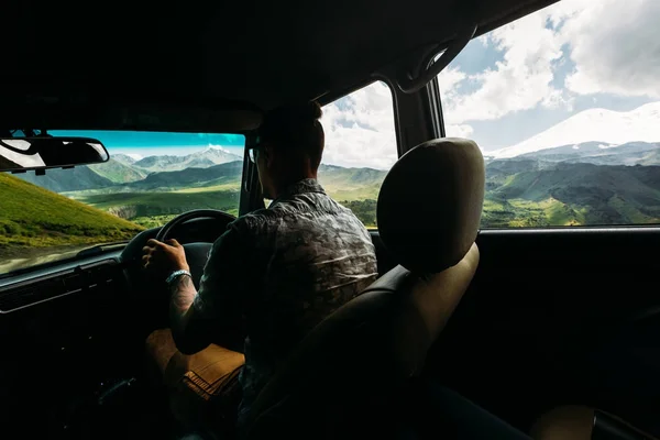 Ung Man Traveler bilkörning i bergen på sommaren, bakre vy från bilen — Stockfoto