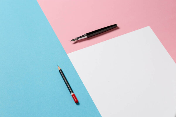 Белый лист бумаги, черный карандаш и ручка на сине-розовой поверхности. Творческий подход
