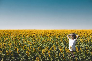 Ayçiçeği içinde ayakta ve kadar eller yükselterek genç güzel kız. Özgürlük yaşam tarzı yolculuk kavramı