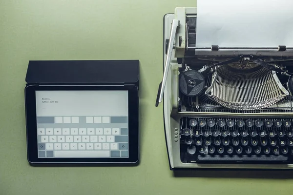 Las máquinas de escribir analógicas y digitales se encuentran en la superficie verde. Continuidad de generaciones, concepto de desarrollo tecnológico — Foto de Stock