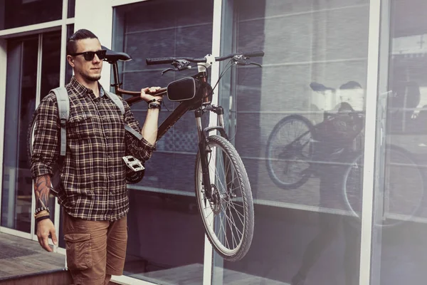 Guapo joven con mochila lleva bicicleta en su hombro Livestyle Daily Routine Concept — Foto de Stock