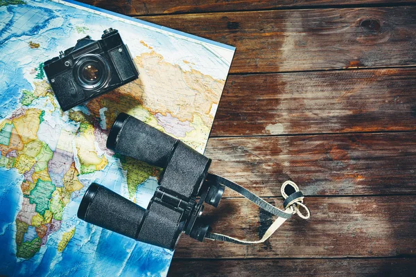Accessori per viaggi Vintage Film Camera, mappa e binocolo su tavolo in legno, vista dall'alto. Avventura Viaggio Scout Journey Concept — Foto Stock