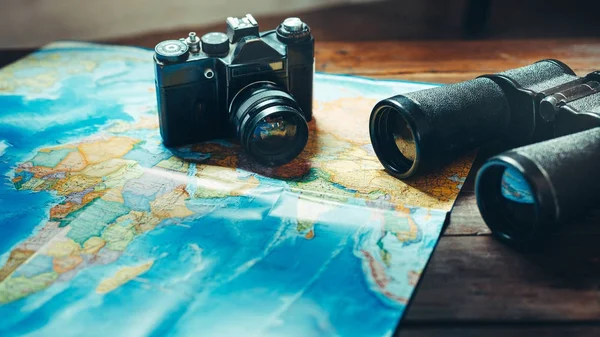 Accessories for travel Vintage Film Camera, Map And Binoculars On Wooden Table, Front View (dalam bahasa Inggris). Konsep Perjalanan Pramuka Petualangan — Stok Foto