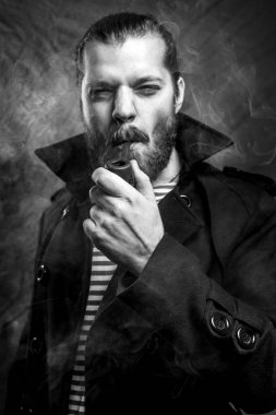 Yakışıklı genç adam Çizgili kıyafetler pipo sakallı. Denizci stil kavramı