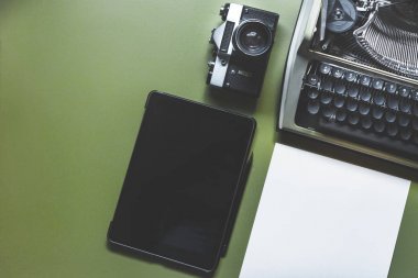 Analog daktilo, dijital Tablet ve Film kamera yeşil masada, üstten görünüm