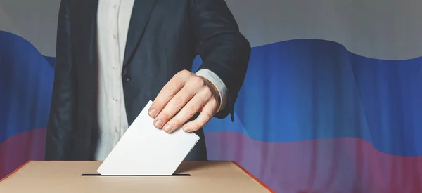 Man Voter Putting Ballot Into Voting box. Democracy Freedom Concept On Flag Background