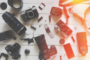 Fotoğrafçı Blogger işyeri, üstten görünüm. Kamera, lens ve Aksesuar ahşap arka plan üzerinde