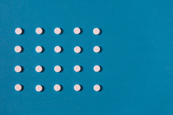 白い錠剤と つ色タブレット コピー スペースと青い背景のパターン 医学医療薬局のコンセプト — ストック写真